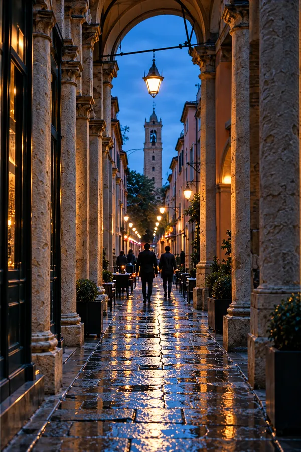 A rain-slick street under long stone porticoes at blue hour, lamps glowing and a tower at its end