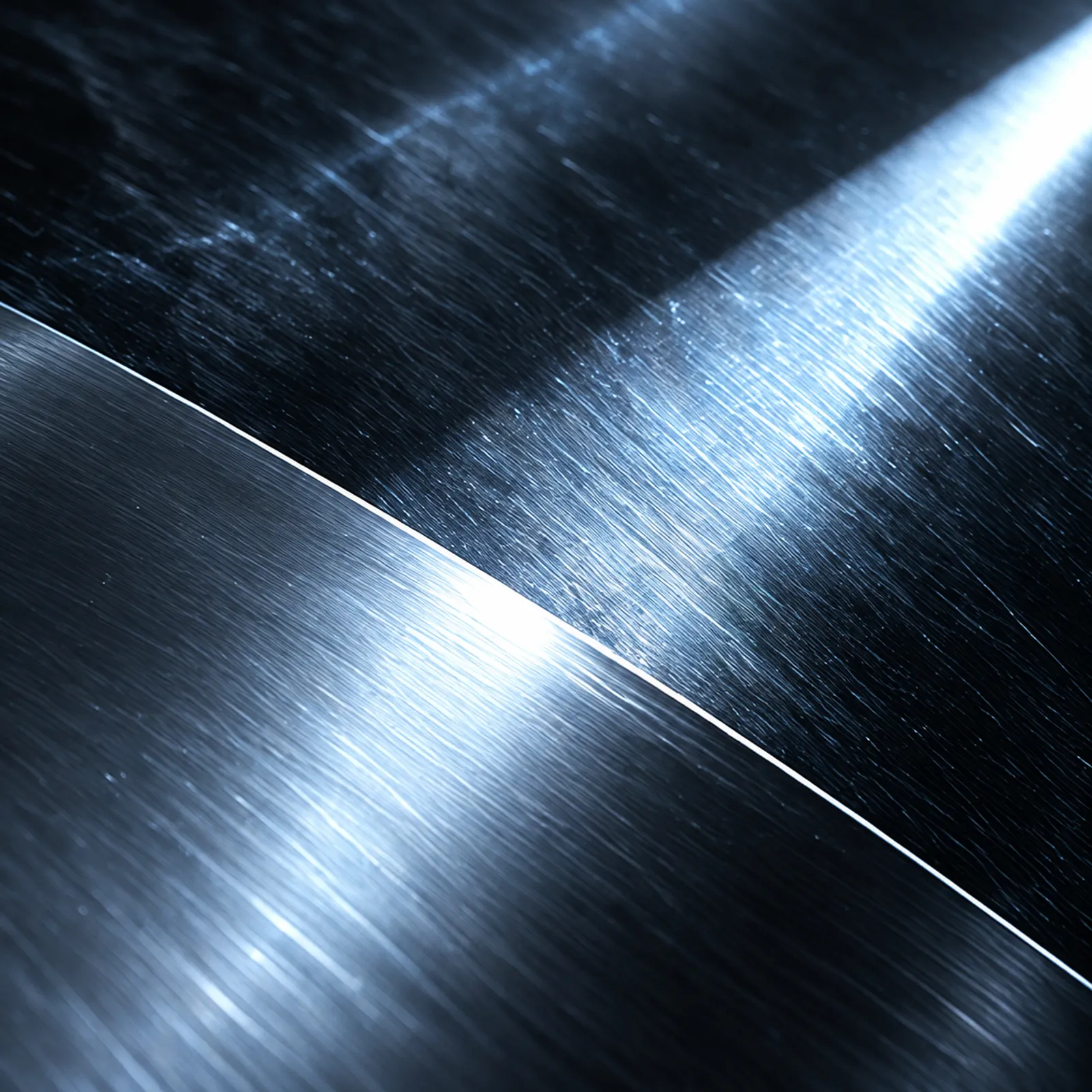 Brushed steel catching a narrow blue-white beam of light along a curved edge