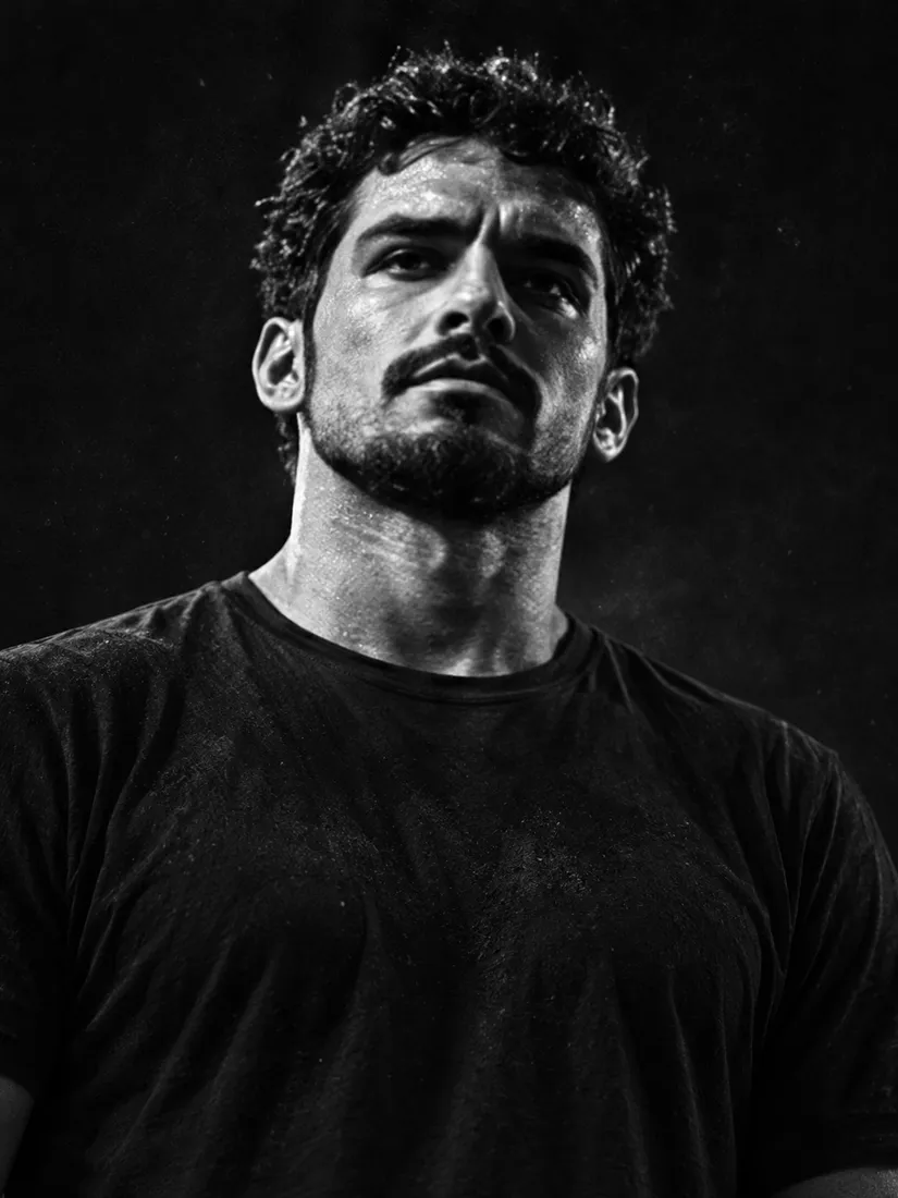 Black-and-white portrait of a man with dark curly hair and a trimmed beard