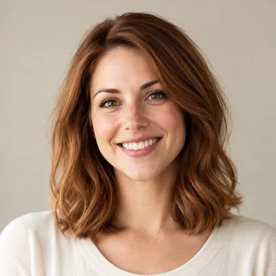 Portrait of Emily R. smiling, with shoulder-length auburn hair