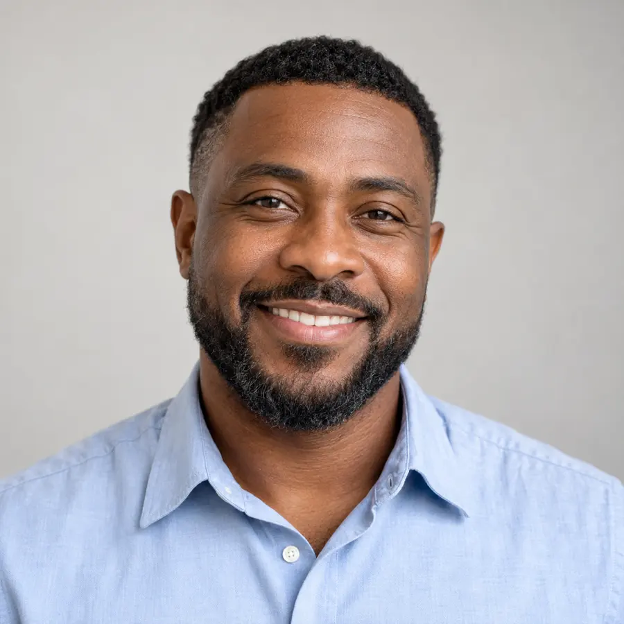Portrait of Daniel Brooks, smiling, with short hair and a neat beard, in a light blue shirt