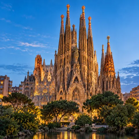 The carved stone spires of a great basilica in Barcelona against a blue sky